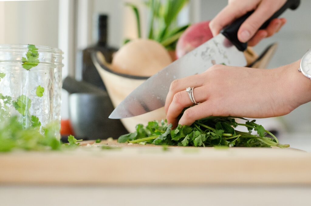 female hand cutting with a knife and chopping vegetables