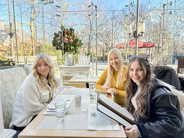 mother and two daughters smiling at a garden restaurant table, showing how to reconnect