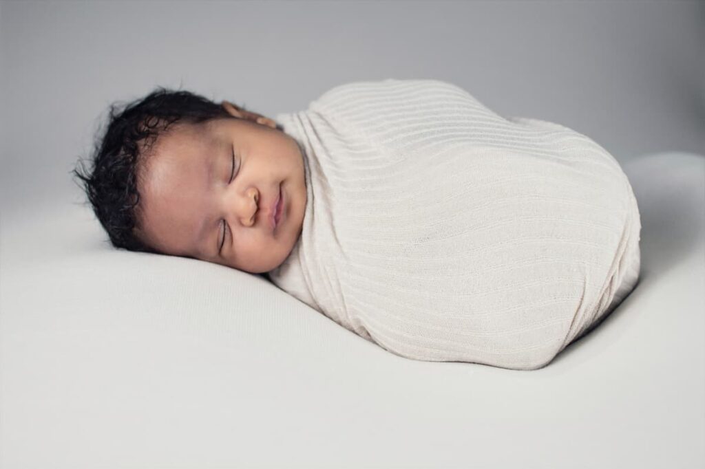 baby swaddled in white