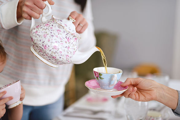 pouring tea from a pot to a cup with saucer - kids tea party ideas