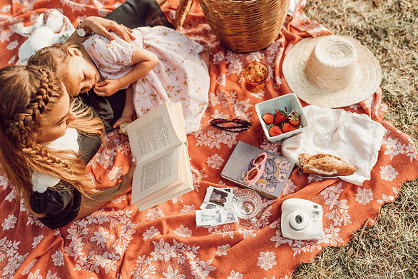 family outings - two girls sharing a picnic on a blanket