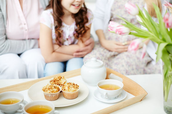girl on couch with tea set in front of her - kids tea party ideas