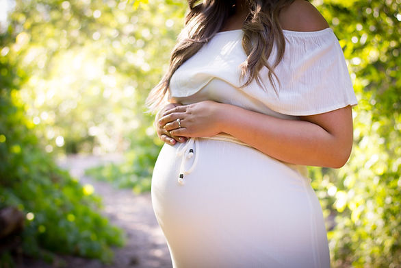 woman in white dress with a full pregnant belly