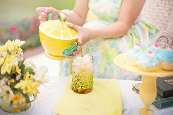 lemon tea pot pouring into a mason jar glass with ice