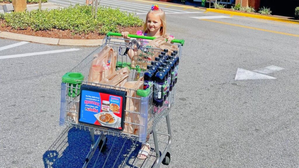 young girl pushing grocery cart - best way to save grocery money