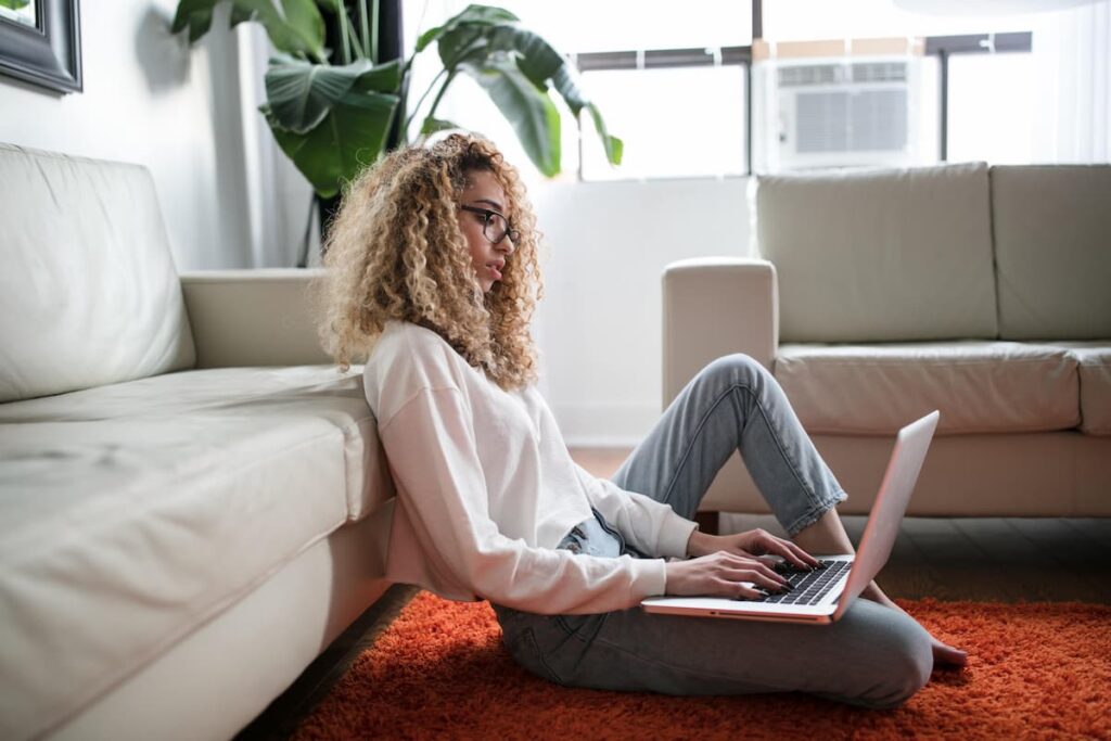 woman sitting on floor using a laptop