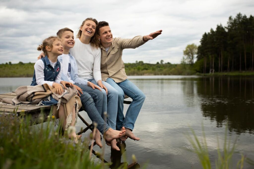 family outings - family of four sitting on a dock smiling