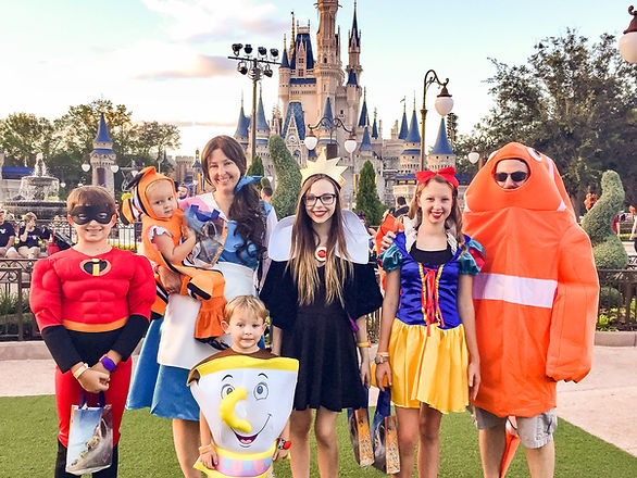disney fastpass - family of seven in Halloween costumes in front of the castle at Disney World Magic Kingdom