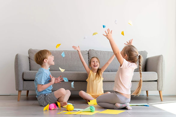 three kids sitting on the floor throwing up paper in the air - what is a yes day