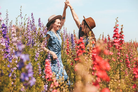 friend photoshoot - two girls in hats twirling one another in a flower field