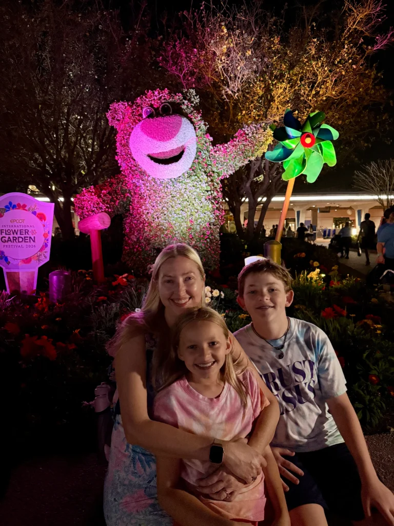 mom with son and daughter at EPCOT, Lotso bear flower sculpture in the back