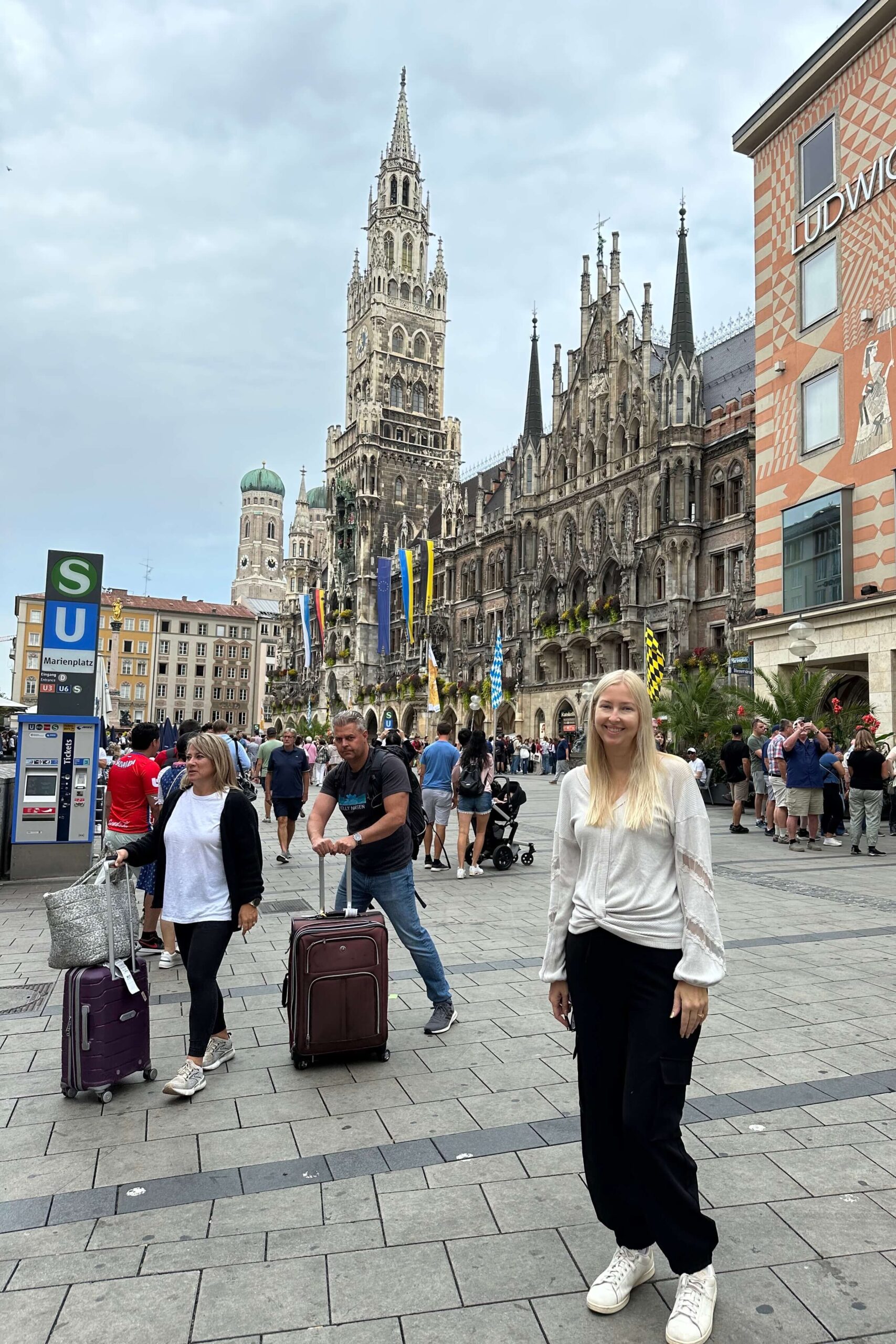 woman in street in Germany, people passing with suitcases and luggage