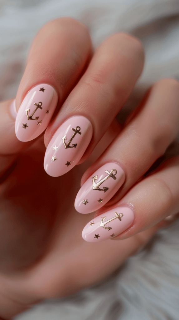 pale pink manicure with golden anchor accents and designs