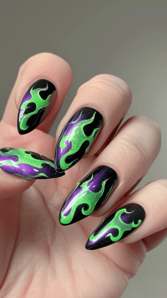 A manicured hand with black nails featuring striking green and purple flame designs inspired by Maleficent. Each nail showcases vivid green and purple flames over a sleek black base, capturing Maleficent's dark and magical essence. 