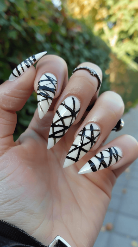 White nails with black polish creating the look of mummy wraps; Halloween nails