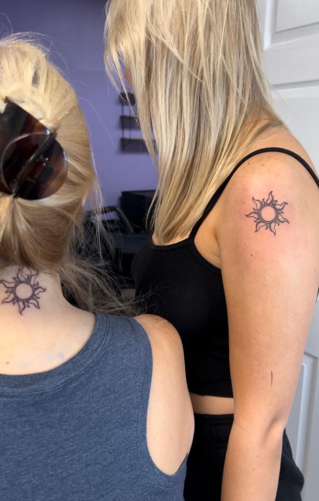 mom and daughter matching tattoos of a sun