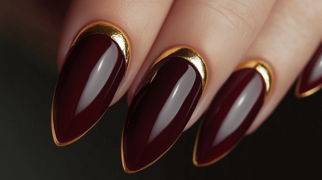 glossy burgundy nails with gold tips and bases