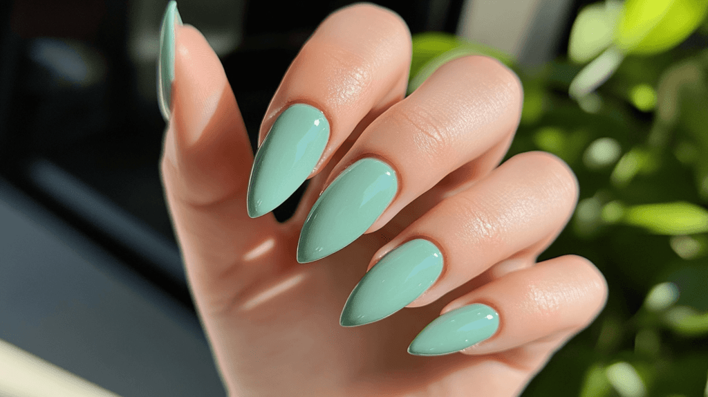 A female hand with a mint green manicure, shown in a natural, relaxed pose.
