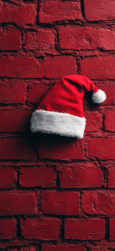 red Santa hat on a red brick wall