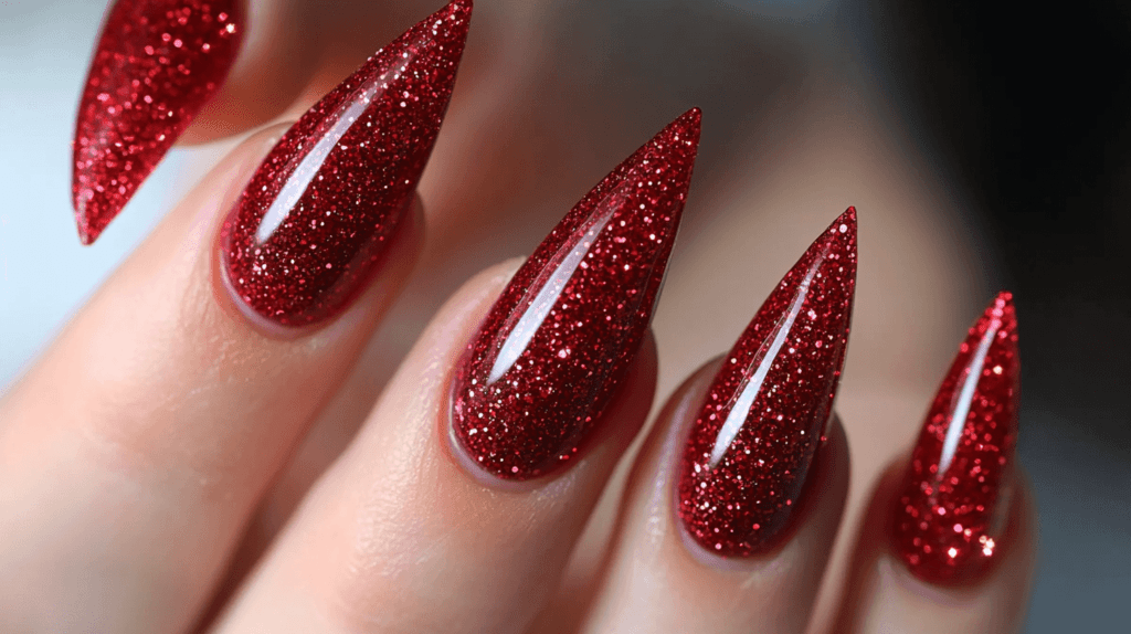 A female manicured hand with glittery red tips