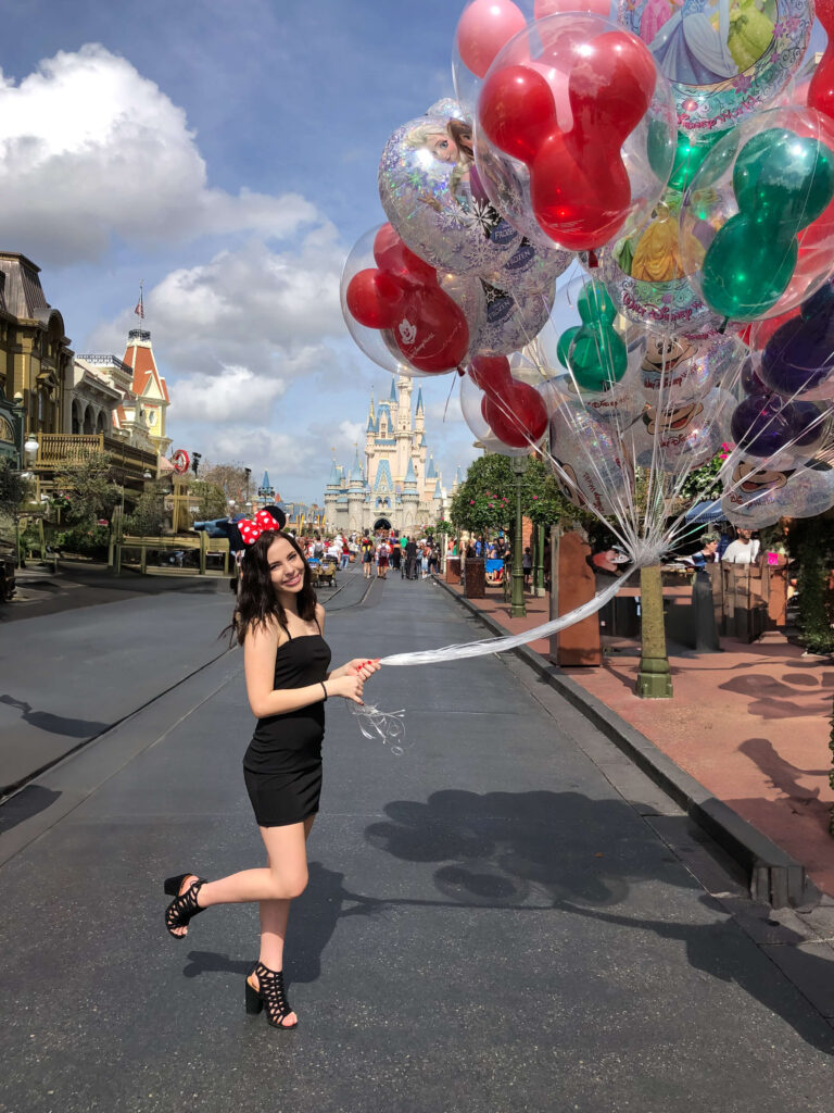 Disney balloons girl holding the large bunch on main street