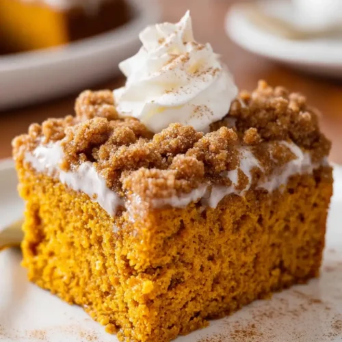 whipped cream topped with cinnamon on pumpkin coffee cake