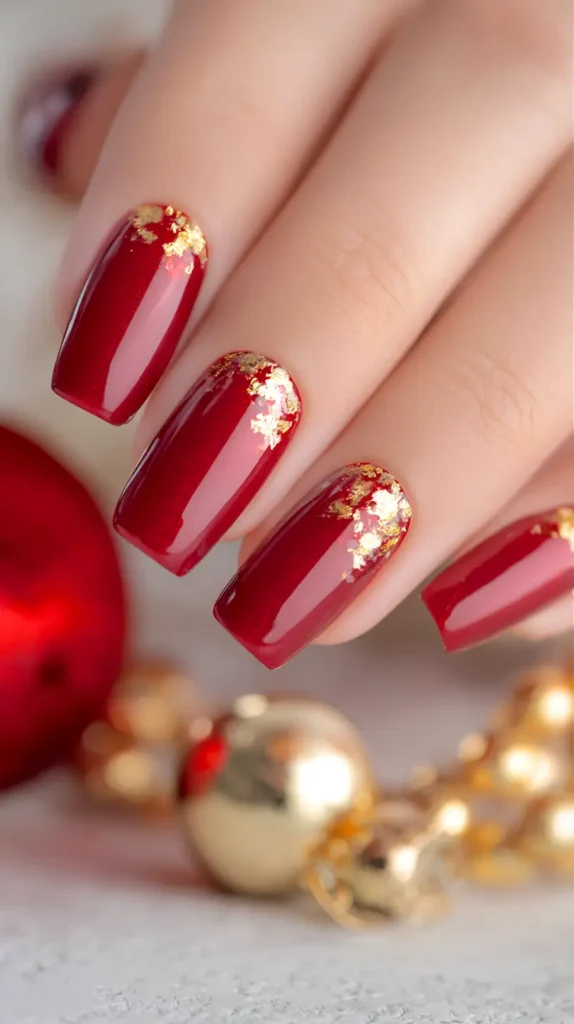 red Christmas nails with gold glitter near the cuticles