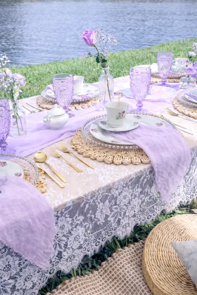 tea party table settings, lace table cloth, tea settings, outdoors, lake in the back