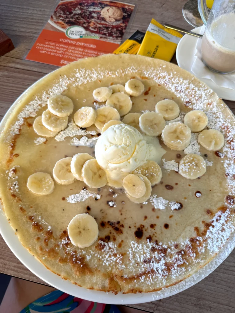 plate of Dutch pancake,  pannenkoeken, with a Pina Colada sauce, whipped cream, and bananas