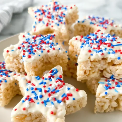 hyper-realistic photo of several rice krispies treat stars arranged on a white ceramic plate, star-shaped cereal treats with visible puffed rice and soft marshmallow binding, half-dipped in smooth white chocolate, topped with red white and blue jimmies sprinkles, slightly glossy coating, crisp chewy texture, festive but realistic, set on a white marble kitchen counter in a bright white kitchen, bright natural window light, clean editorial food photography, sharp focus, realistic sizes and textures, no people, no hands, no text, no watermark